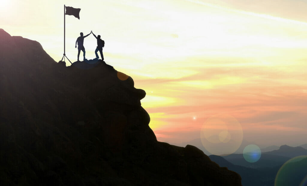 Photo of climbers celebrating on a mountaintop,